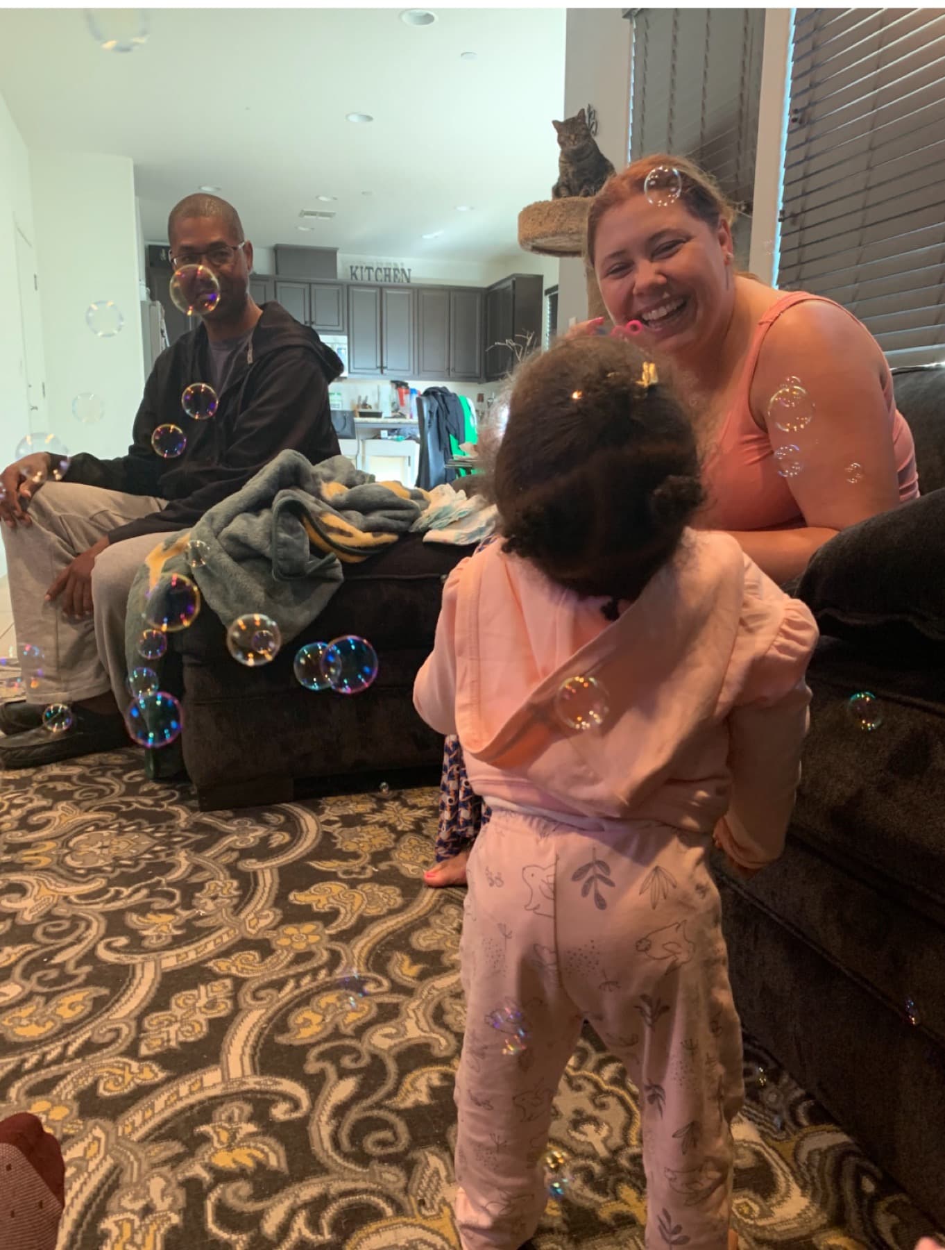 Carrie Phillips laughing with family while bubbles float through the room